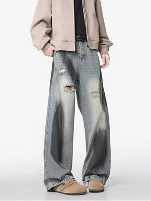 Distressed wide-leg jeans with belted detail and faded wash.