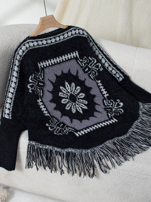 Black acrylic knit poncho with Aztec motif and fringe detail.
