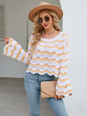White crochet sweater with orange-red wavy stripes and bell sleeves.