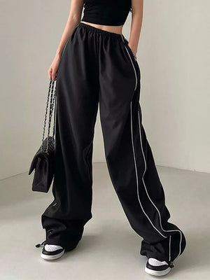 Black wide-leg maternity pants with gathered waistband and white piping detail.
