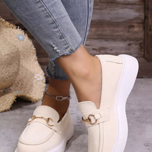 White loafers with gold horse-bit detail and platform sole.