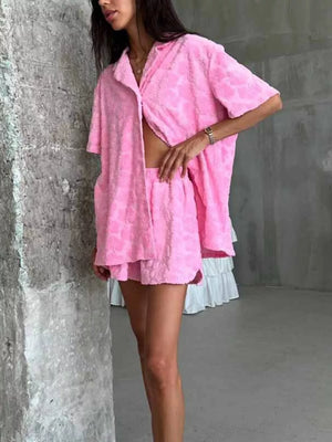 Pink textured floral button-up shirt and shorts set with short sleeves.
