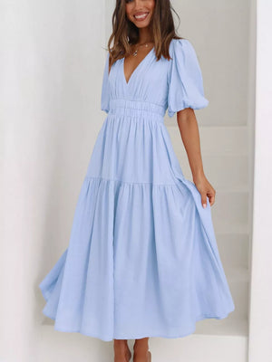 Light blue midi dress with V-neck, puff sleeves, cinched waist, and tiered skirt.