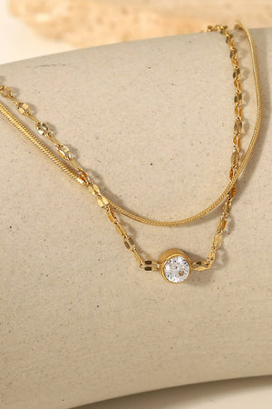 Gold double-strand bracelet with pavé charm and delicate chains.