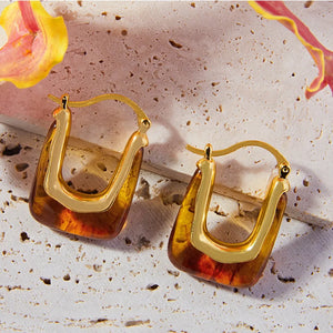 Gold geometric hoop earrings with amber resin inlay.