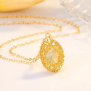 Gold openwork pendant necklace with delicate chain and sunburst detail