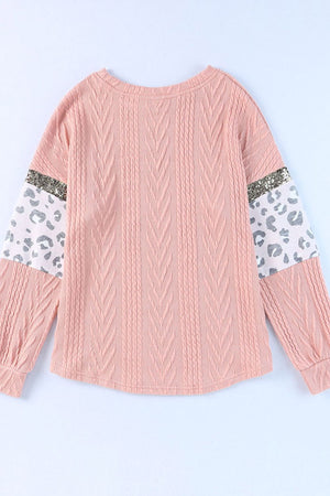Pale blush sweater with textured chevron knit, leopard print sleeves, and sequin detail.
