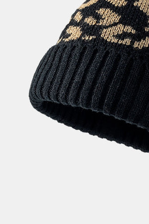 Black acrylic beanie with textured leopard print and ribbed cuff.