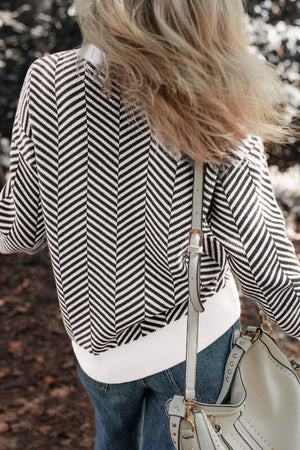 Black and white chevron knit crewneck sweater with white ribbed hem.