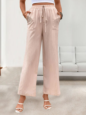 Apricot linen palazzo pants with drawstring waist and side pockets.