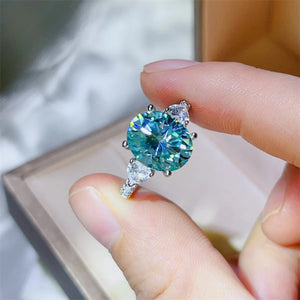 Turquoise moissanite trilogy ring in 925 sterling silver with pear cut accents