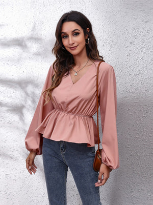 Dusty pink peplum blouse with V-neck, gathered waist, and balloon sleeves.