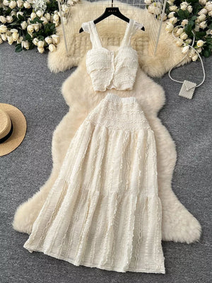 White textured two-piece set with ruffled details, buttoned crop top and tiered midi skirt.