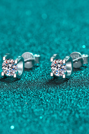 Silver moissanite stud earrings with sculpted settings and clear round-cut stones.