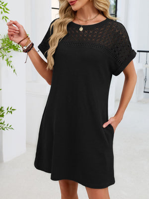 Black t-shirt dress with short sleeves, round neck, lace yoke detail, and pockets.