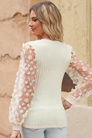 Cream knit blouse with sheer floral appliqué sleeves