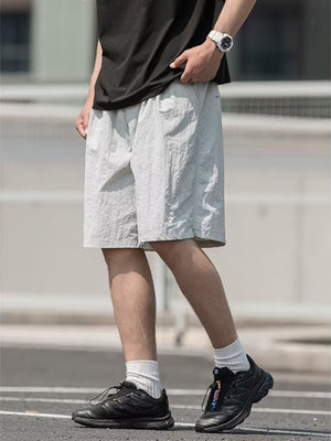 Men's light gray textured drawstring shorts with elastic waistband and pockets.