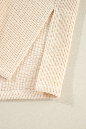 Beige corduroy utility jacket detail showing textured fabric and a side slit.