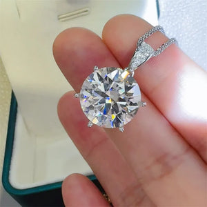 Silver moissanite solitaire pendant with a large round-cut stone and a diamond-accented bail.