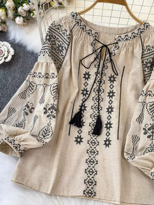 Apricot embroidered tie neck blouse with tassels and voluminous sleeves.