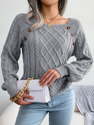 Cable-knit sweater in charcoal with buttoned shoulder detail and square neckline.