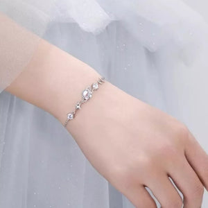 Silver celestial bracelet with zircon stars and a central moon charm.