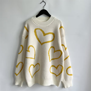 Cream acrylic knit sweater with yellow heart pattern, crew neck, long sleeves.
