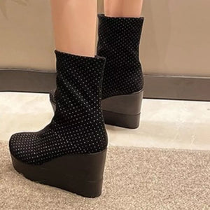 Black polka dot suede wedge boots with platform and wedge heel.
