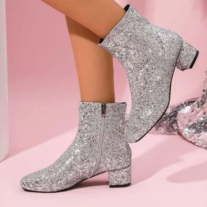 Silver sequin ankle boots with a block heel and side zipper.
