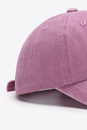 Washed cotton baseball cap in magenta with adjustable strap detail.