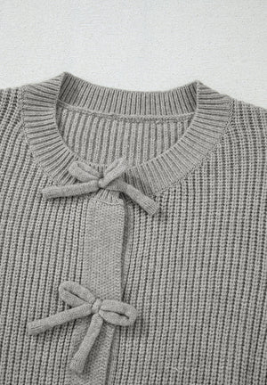 Gray ribbed knit cardigan with tie-front detail and bow accents.