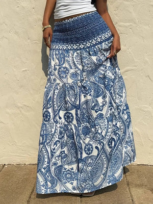 Bohemian maxi skirt in blue paisley print with smocked waist and tiered ruffles.