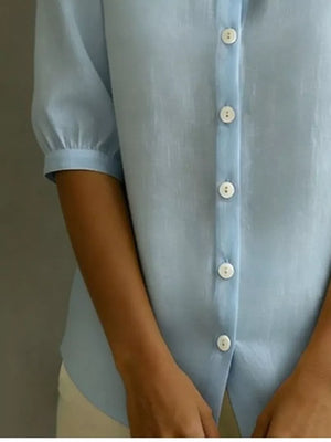 Light blue button-down shirt with puff sleeves and white buttons.