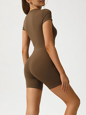 Brown short sleeve zip-front bodysuit with a sculpted fit and bike short length.