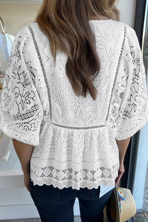White lace peplum blouse with short sleeves, scalloped hem, and intricate eyelet details.