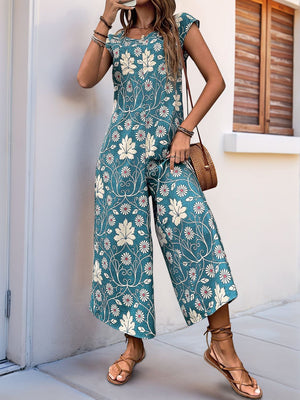Botanical print culotte jumpsuit in turquoise with short sleeves and a round neckline.