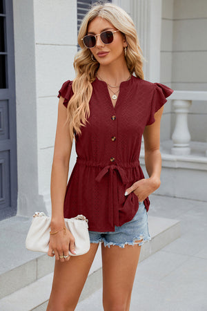 Burgundy textured eyelet peplum blouse with tie waist and flutter sleeves.