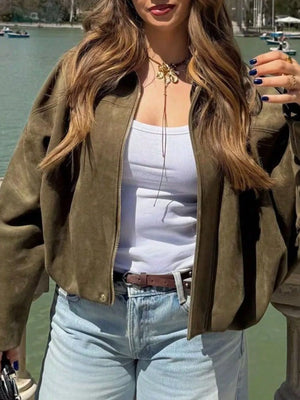 Oversized military green zip-up jacket with a ribbed hem and cuffs, styled with a white tank top.