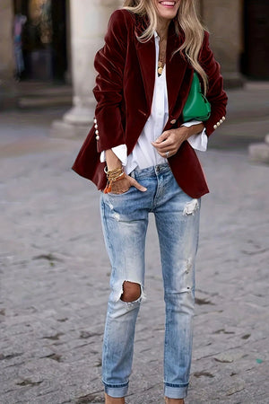 Burgundy velvet bolero jacket with ornate buttons, styled with a white shirt and distressed jeans.