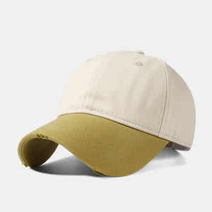 Distressed two-tone baseball cap in tan and olive green cotton with curved brim.