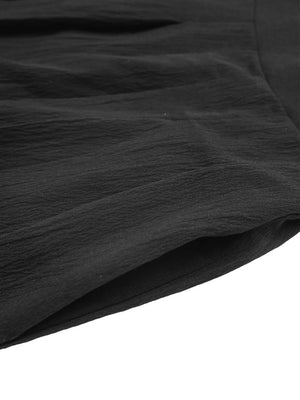 Black pleated shorts with textured fabric and pocket detail