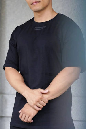 Black oversized t-shirt with subtle tonal logo detail on chest