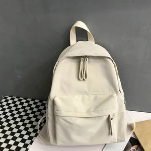 Ivory canvas backpack with dual zipper pockets and front zip pocket.