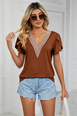 Brown V-neck blouse with lace trim and flutter sleeves, styled with denim shorts.