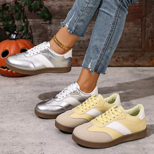 Metallic patent leather lace-up sneakers in silver and yellow with white accents.
