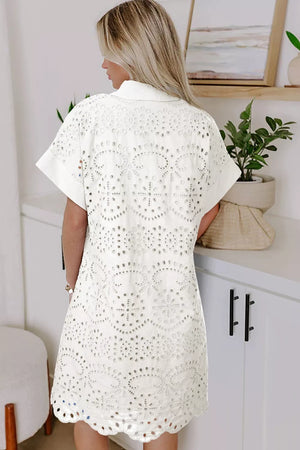White eyelet embroidered mini dress with short sleeves and a collared neckline.