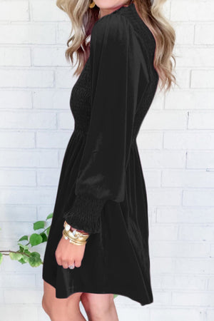 Black velvet mini dress with smocked bodice and long puff sleeves.