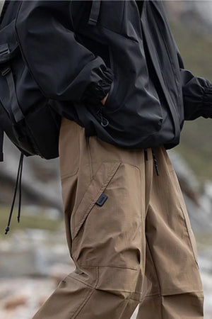 Men's brown cargo pants with drawstring waist and multiple pockets.