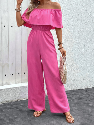 Off-the-shoulder ruffled waist jumpsuit in hot pink with wide legs.