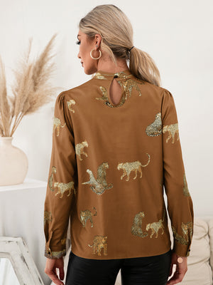 Caramel leopard print blouse with keyhole neck and puff sleeves.